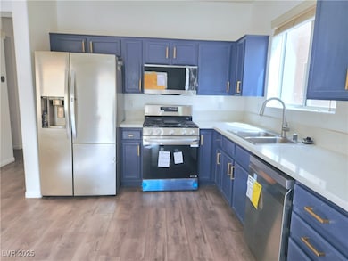 Kitchen with light countertops, blue cabinetry, a