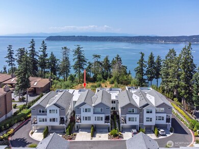 The red arrow is pointing at the roof top deck exclusive to this unit. The Olympics are in the distance with Possesion Point, the south tip of Whidbey Island, across the bay.