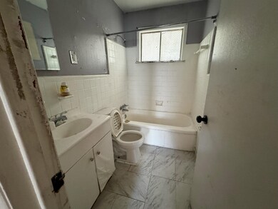 Full bathroom featuring tile walls, vanity, toilet