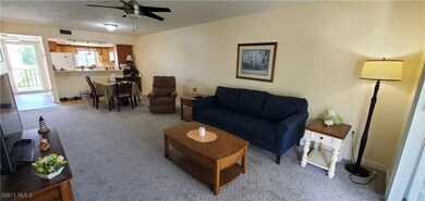 Carpeted living room with ceiling fan
