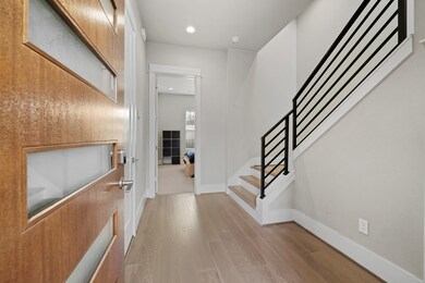 This photo shows a modern entryway with a wooden d