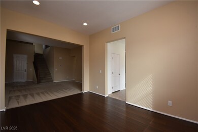 Empty room featuring stairs, wood finished floors, baseboards, visible vents, and recessed lighting
