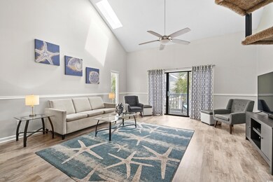 Living room with high vaulted ceiling, light wood-