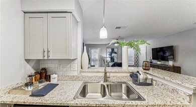 Kitchen featuring a textured ceiling, backsplash, 