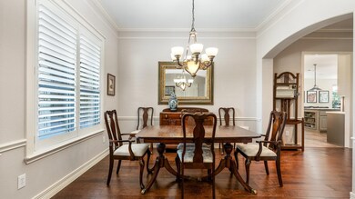 Dining area featuring ornamental molding, dark woo