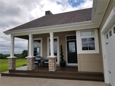 Covered front porch features stained concrete and 