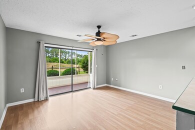 Unfurnished room featuring light wood-style floors, ceiling fan, baseboards, and a textured ceiling