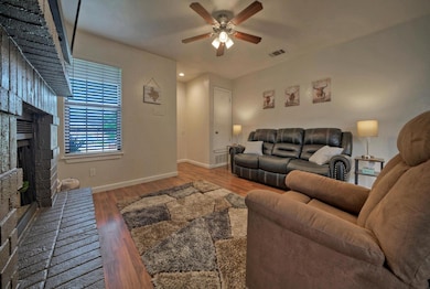 Living room with a brick fireplace, ceiling fan, 