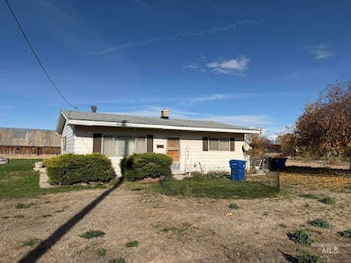 View of front of property with a chimney, a front lawn, and roof with shingles