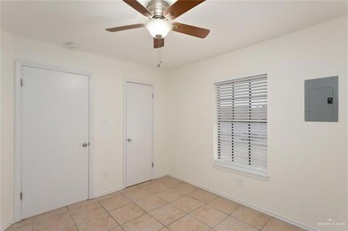 Unfurnished bedroom featuring light tile patterned floors, electric panel, and a ceiling fan