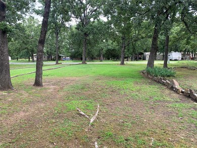 View of green lawn featuring view of scattered trees