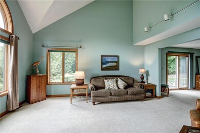 Living room has cathedral ceiling and large windows for great view of lake.