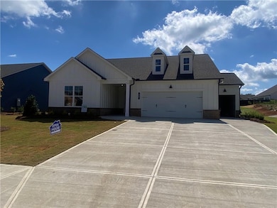 Modern farmhouse featuring brick water table line, a 2 car  garage plus a separate carriage garage and board and batten siding