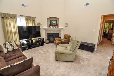 A cozy gas log fireplace with arched TV niche high
