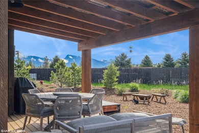 Fenced backyard with outdoor dining space, a grill, and a mountain view