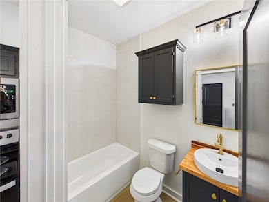 Full bathroom featuring vanity, shower / bathtub combination, and wood finished floors