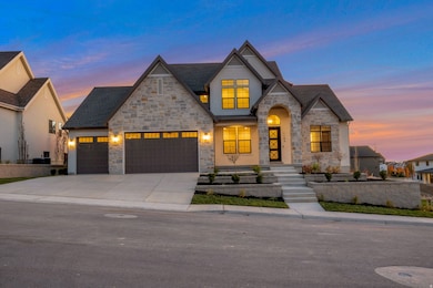 French country home featuring stone siding, driveway, an attached garage, and a shingled roof