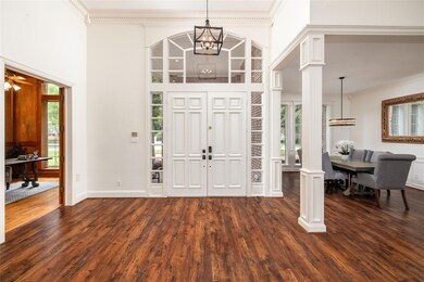 Beautiful entry, with high ceilings, chandelier, ornamental moulding  and ornate columns.