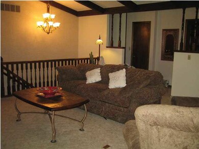 Living room w/ view of steps to basement