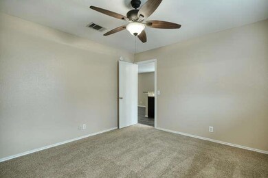 Spare room with a ceiling fan, carpet, and basebo