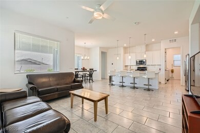 Living room featuring a ceiling fan, a chandelier,