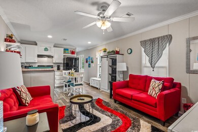 Living room featuring ceiling fan, crown molding, 