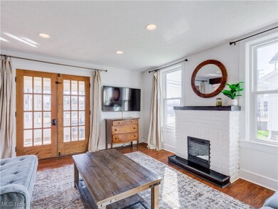 Living room with a fireplace, dark hardwood / wood-style floors, and french doors