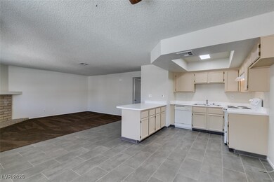 Kitchen featuring white appliances, a peninsula, a
