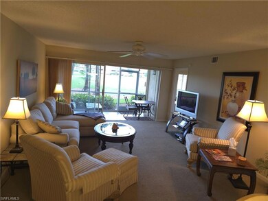 Living room with carpet flooring, a ceiling fan, a