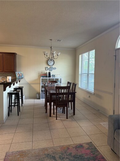 Dining room featuring ornamental molding, a chande