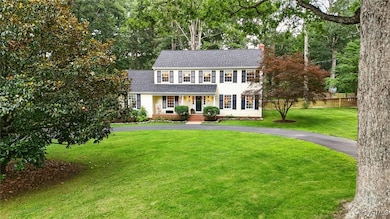 Colonial inspired home with a chimney, a shingled
