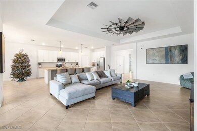 Tiled living room with ceiling fan and a raised ce