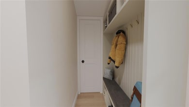 Mudroom with light wood-type flooring and baseboar