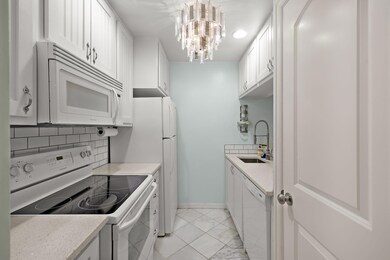 Kitchen with light countertops, white appliances,