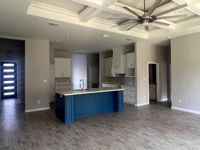 Kitchen featuring coffered ceiling, a sink, wood finished floors, white cabinets, and ceiling fan