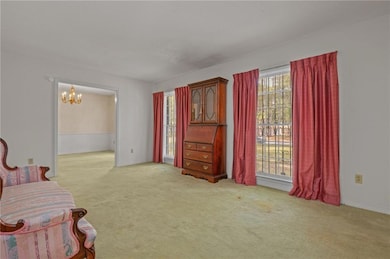 Sitting room featuring light carpet and a chandelier