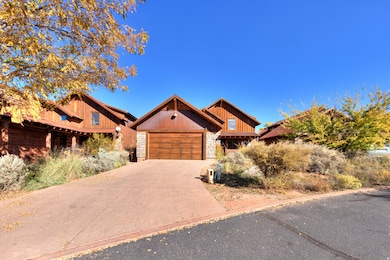 View of front of home featuring stone siding, driveway, a garage, and board and batten siding