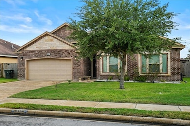 View of front of home with a garage, concrete driveway, and brick siding