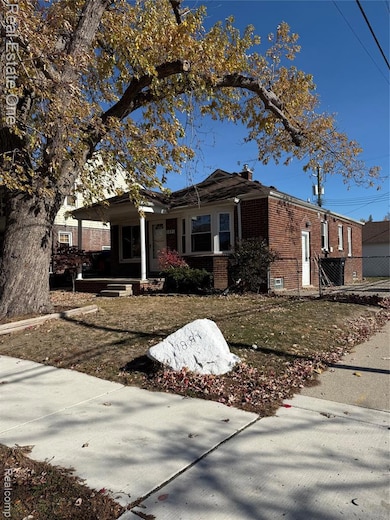View of front of home with brick siding, a chimney, and a porch