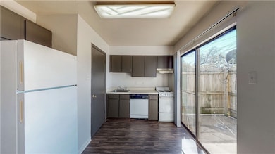 Kitchen with a sink, dark wood finished floors, wh