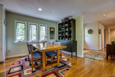Eat-in area of kitchen has hardwood floors and is open to family room