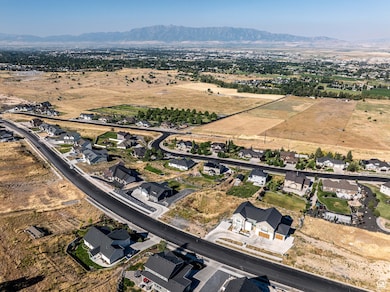 Aerial overview of property's location with rural landscape, a mountain backdrop, and nearby suburban area