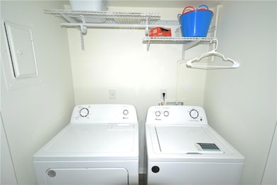 Laundry room with electric panel and washing machi