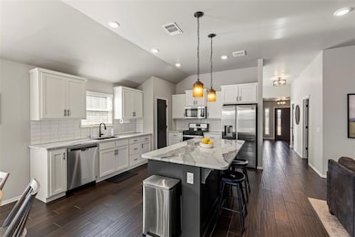 Kitchen with lofted ceiling, appliances with stain