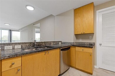 Kitchen with stainless steel dishwasher, dark stone countertops, light marble finish flooring, and recessed lighting