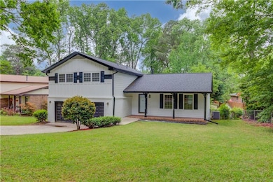 Split level home featuring a porch, fence, drivewa