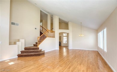 Unfurnished living room featuring a chandelier, li