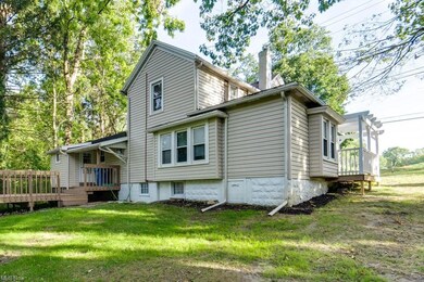 Rear view of property with a lawn and a deck