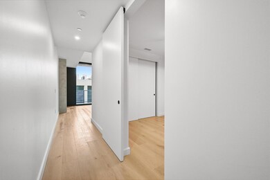 Corridor with light wood-style floors and recessed lighting