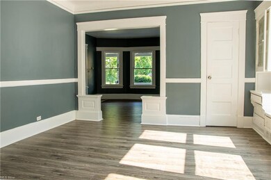 Hardwood floored dining room featuring ornamental molding